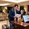 ホテルのフロントで予約がなく困惑する男性